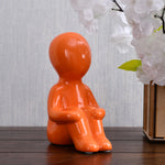 Boy Sitting with Folded Legs Polyresin Decorative Showpiece (Orange)